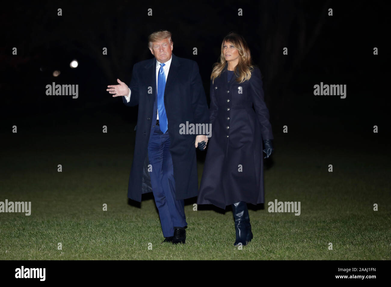 Il Presidente degli Stati Uniti, Trump onde come egli cammina con la prima signora Melania Trump sulla South Lawn della casa bianca dopo il loro ritorno a Washington DC da Dover, Delaware dove hanno testimoniato la dignitosa di trasferimento i resti di due soldati americani uccisi in Afghanistan il 21 novembre 2019. Credito: Yuri Gripas / Pool via CNP /MediaPunch Foto Stock