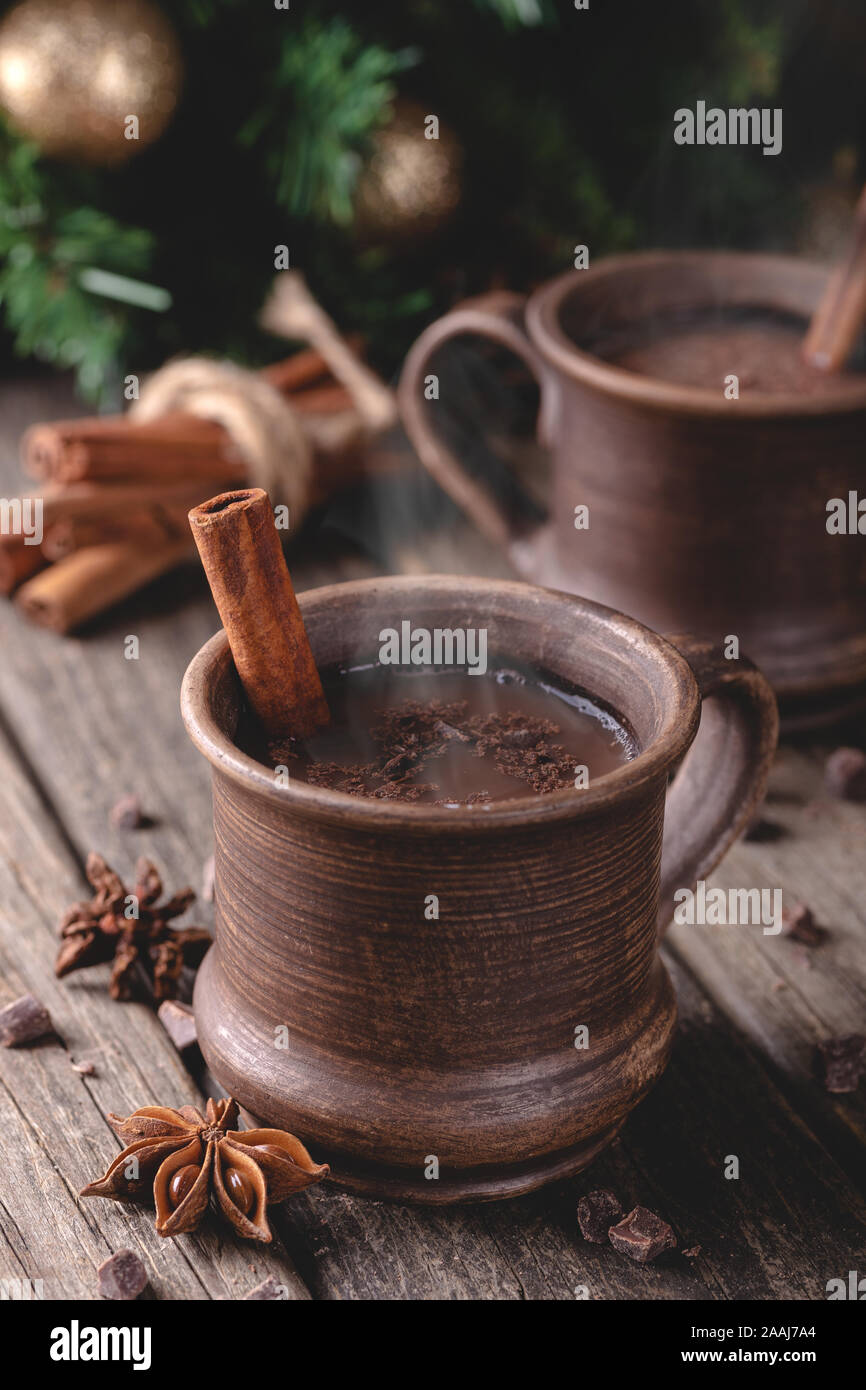 La tazza fumante di cioccolata calda sul rustico superficie in legno con albero di Natale in background Foto Stock