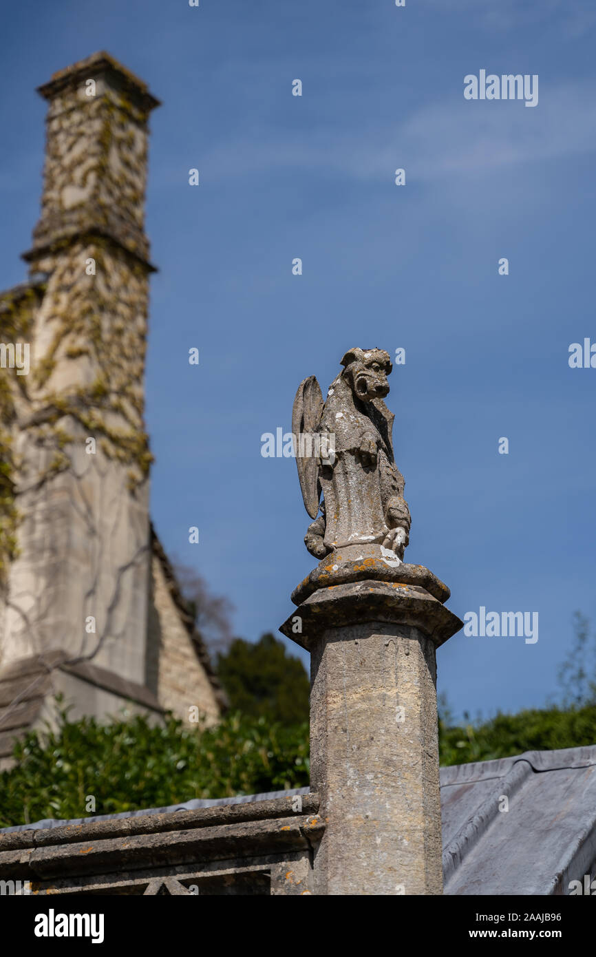 Gargoyle di pietra statua scolpita da roccia sul tetto di una chiesa in Cotswolds Inghilterra, Regno Unito. Foto Stock