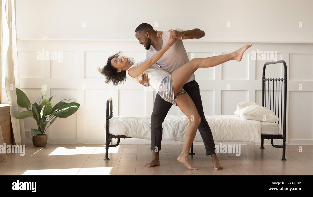 Felice americano africano coppia danzante insieme in camera da letto Foto Stock