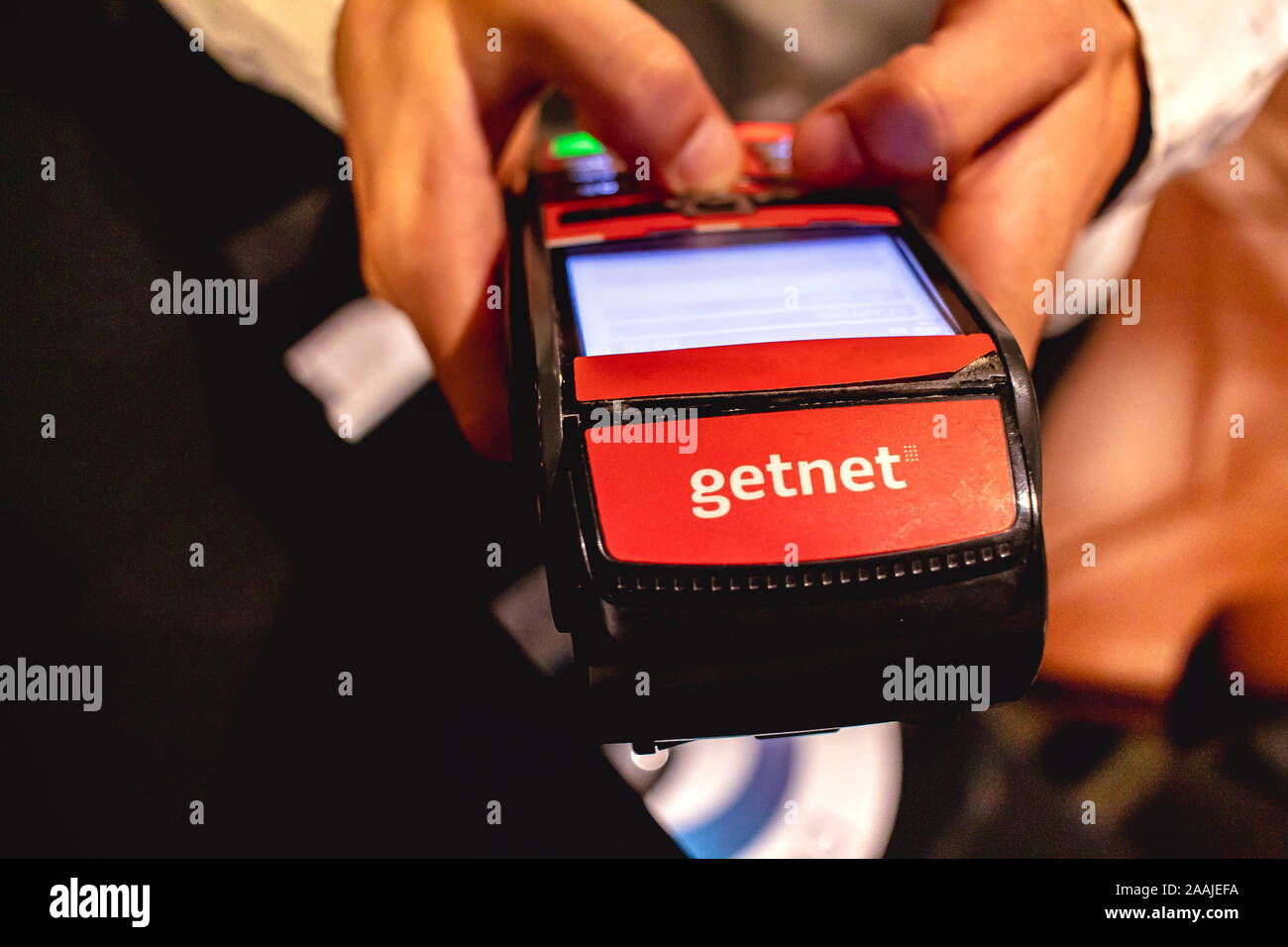 L'uomo holding società Getnet di carte di credito e di debito macchina. Foto Stock