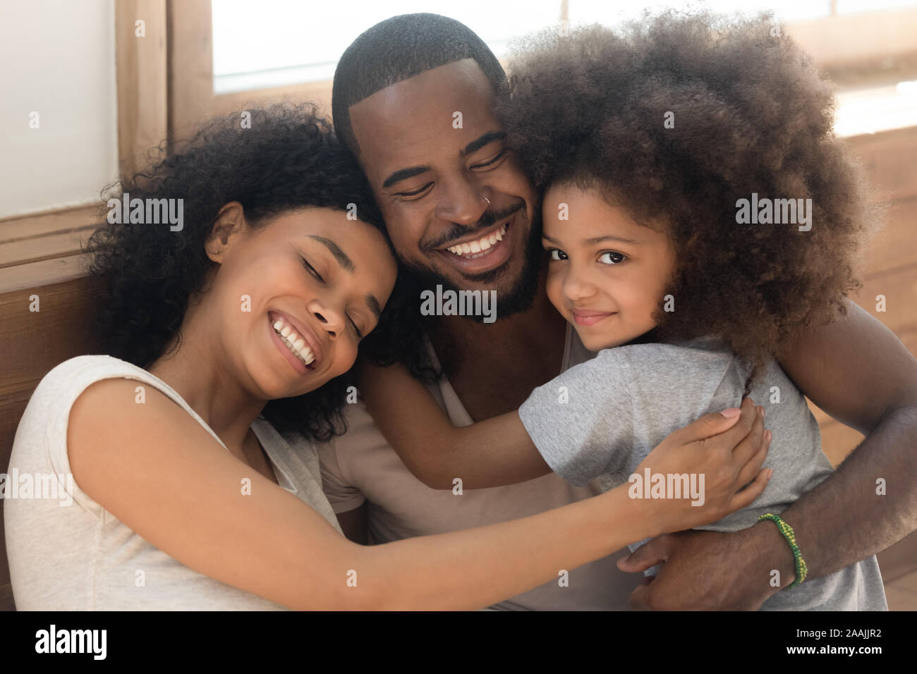 Felice americano africano giovane con bambino abbracciare a casa Foto Stock