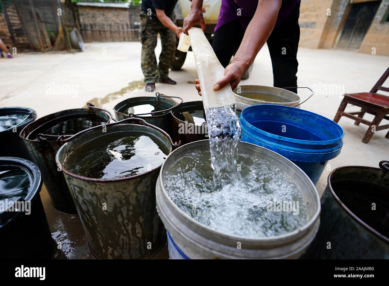 (191122) -- YICHENG COUNTY, nov. 22, 2019 (Xinhua) -- staff di lavoro consentono di distribuire acqua per un abitante di un villaggio nel villaggio di Nanling della contea di Yicheng, nel nord della Cina di nella provincia di Shanxi, 3 luglio 2019. Come l'interruttore è stato tirato, l'acqua forma di schizzo da 403 metri giù sotto. Villaggio Nanling molto prima di acque profonde è andato bene in servizio su un inizio inverno mattina. In passato il borgo, diffusione attraverso gli anfratti delle montagne Zhongtiao nel nord della Cina era basata esclusivamente sul fango box per conservare la sua preziosa acqua potabile per secoli. Ossessionato dalla paura della siccità, generazioni aveva sognato di diretta Foto Stock