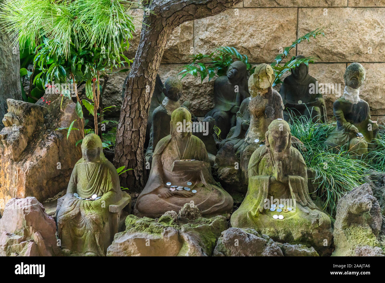 Statue in pietra di sedici arhats del Buddismo Zen con piastre commemorative Itahi adornata con un segno di Sanscrito nel tempio Choanji in Tokyo. Foto Stock