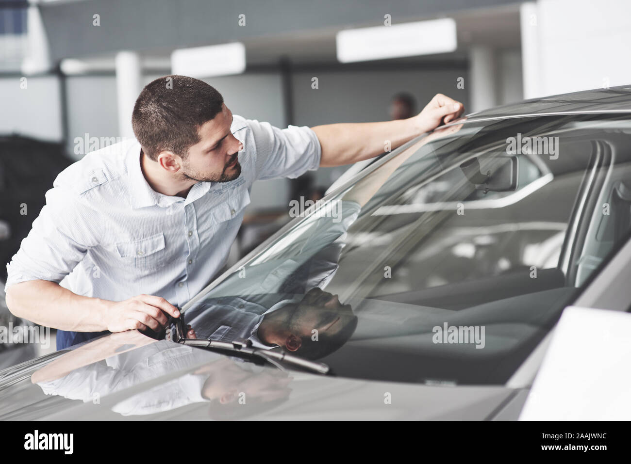 Uomo felice di toccare auto in auto show o salone. Foto Stock