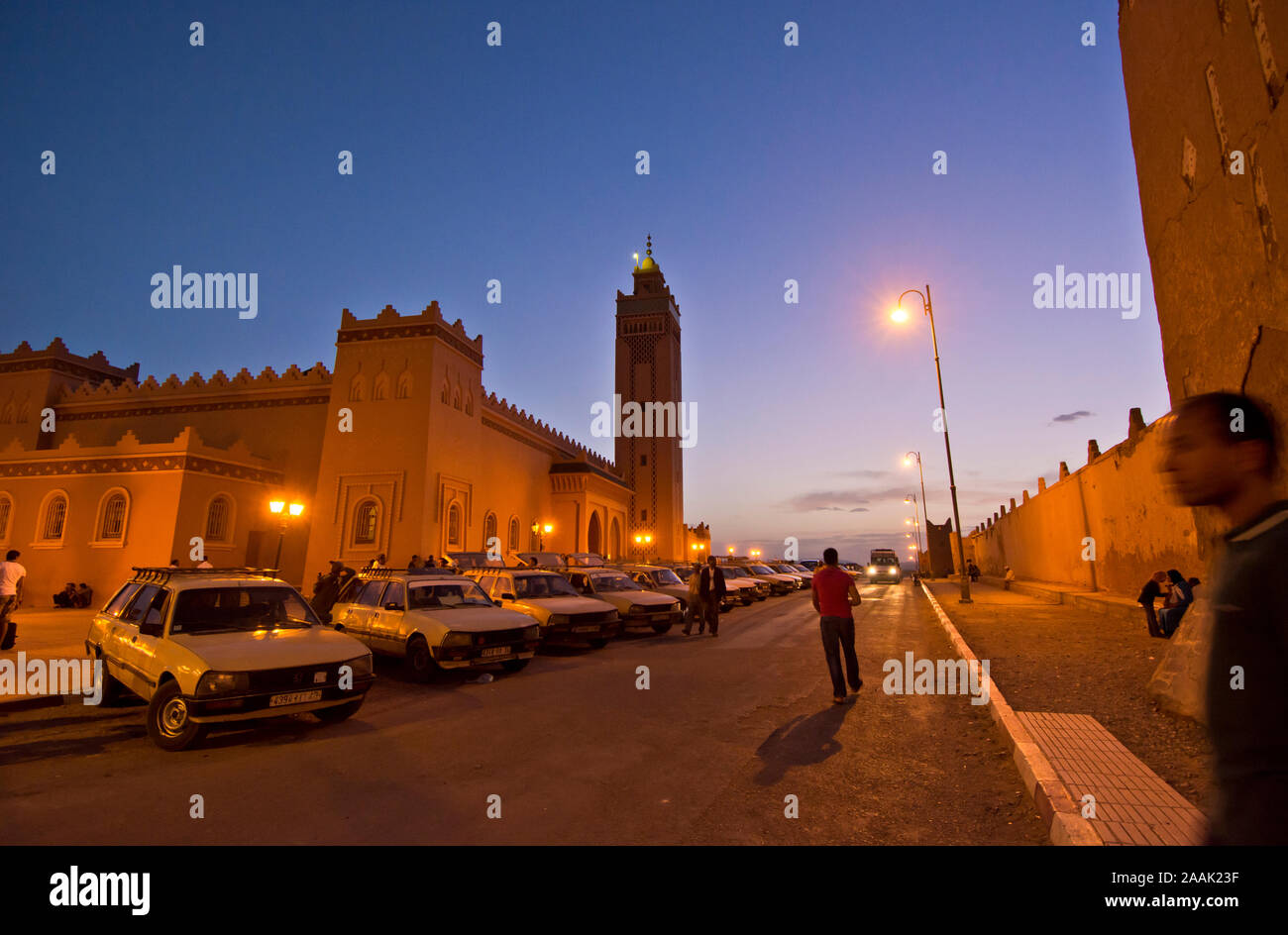 Grand Taxi e la moschea al crepuscolo, Zagora. Valle di Draa, Marocco Foto Stock