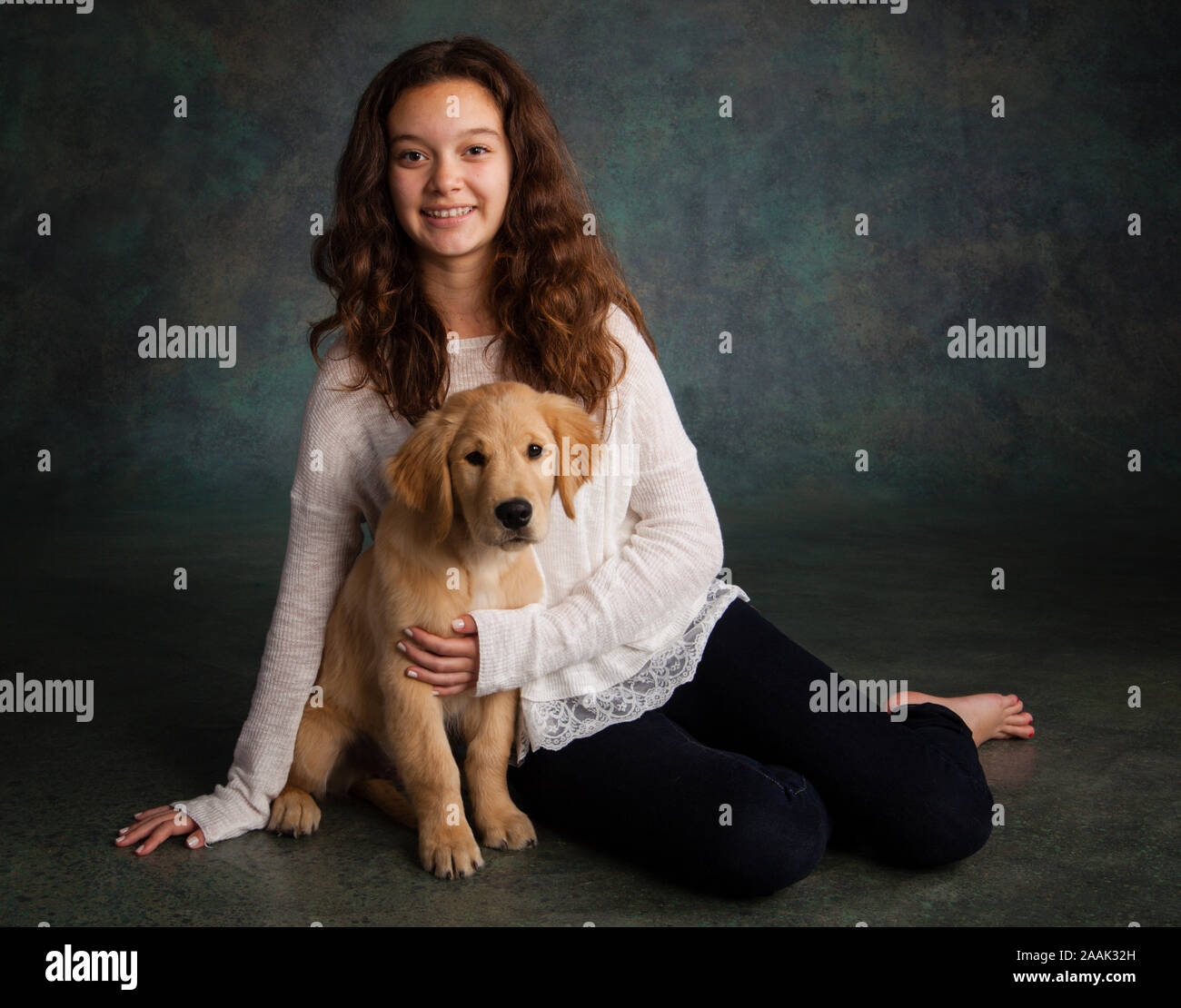 Ritratto in studio della ragazza adolescente con il Golden Retriever cucciolo Foto Stock