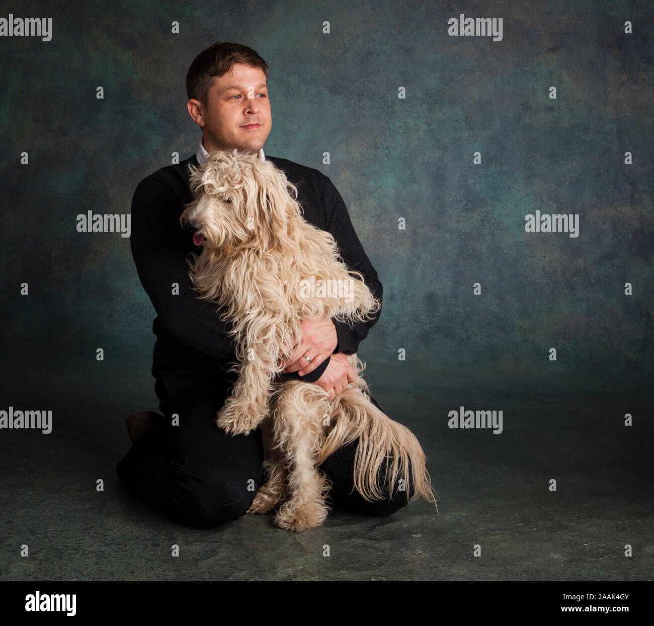 Ritratto in studio di uomo con Mini Golden Doodle Foto Stock