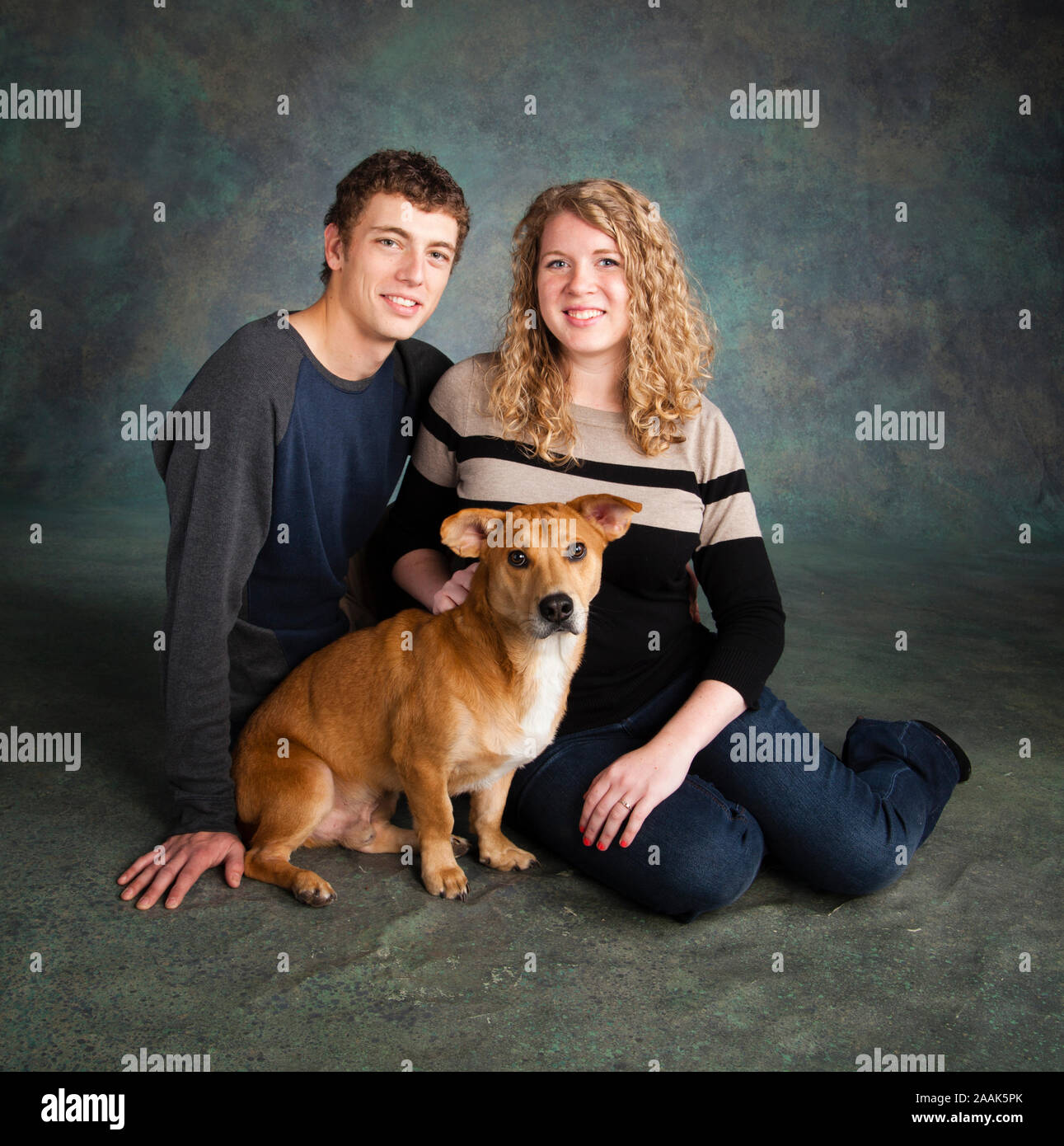 Ritratto in studio della coppia sorridente con Westie Labrador cane misti Foto Stock