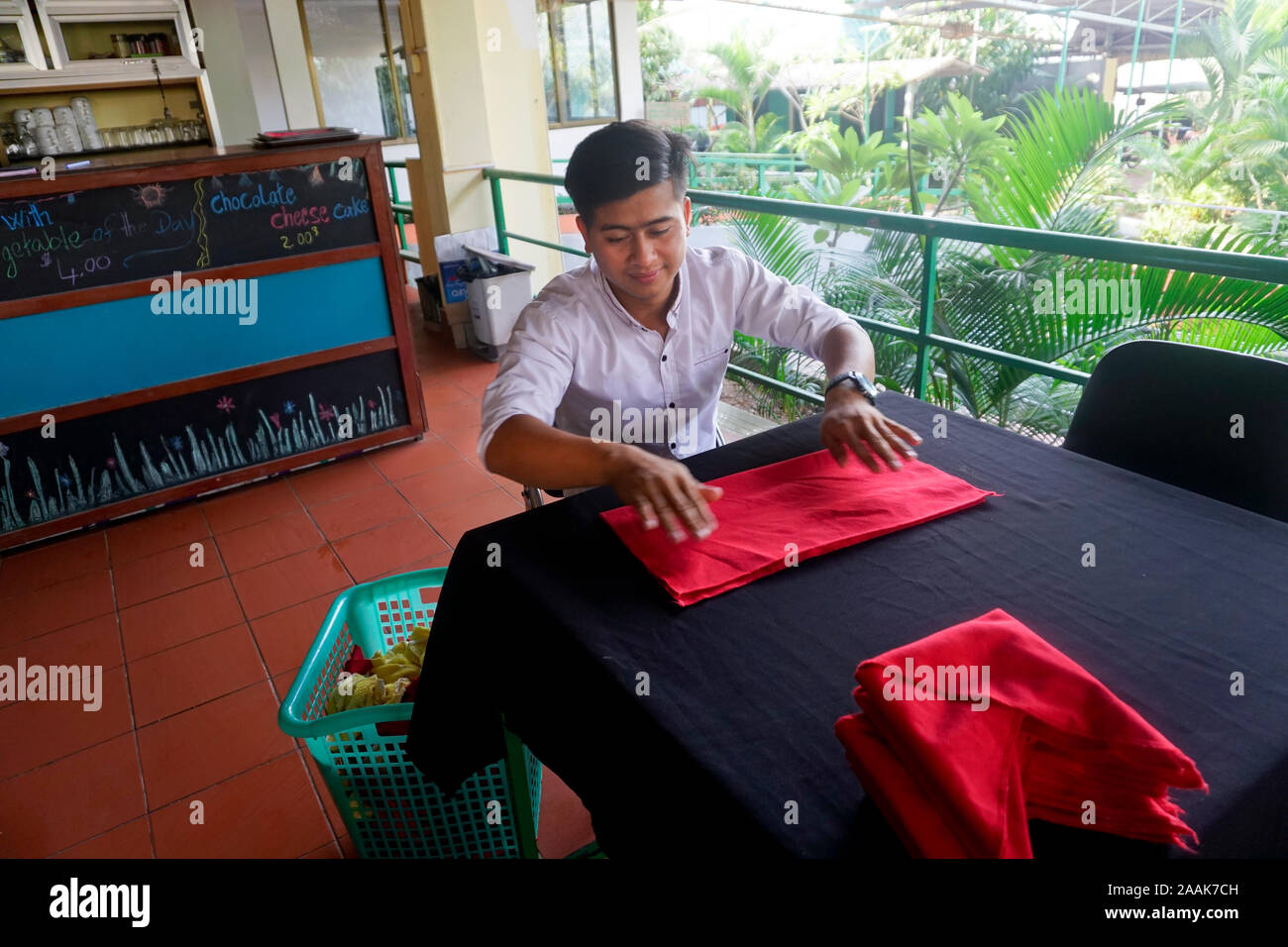 I giovani cambogiani uomo che lavora presso l'hotel, Kratie, Cambogia dopo andare in un hotel scuola di formazione di Kratie. Foto Stock