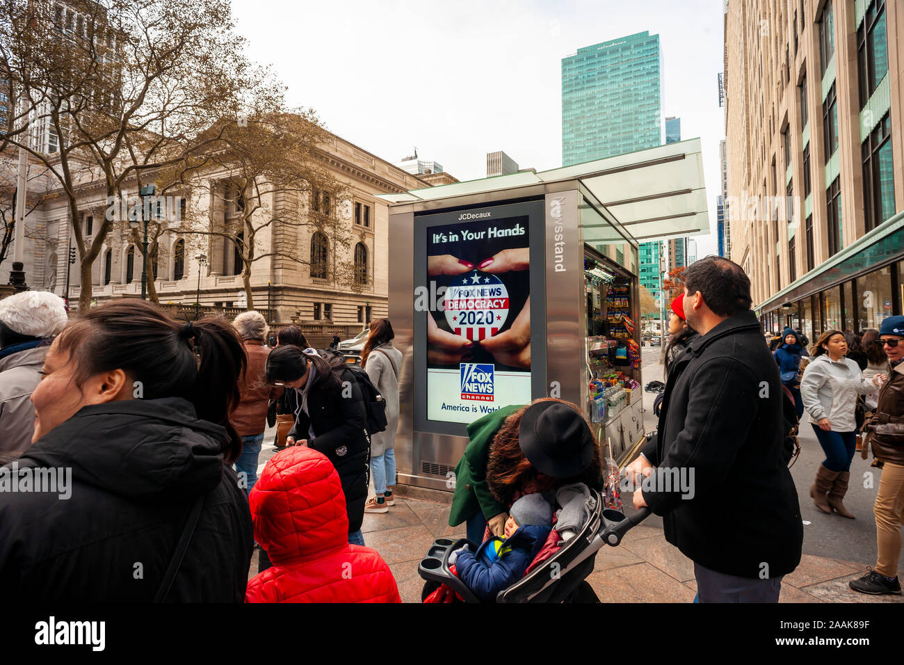 Pedoni attendere per attraversare la 42nd Street a New York davanti a un display digitale pubblicità Fox News' copertura del 2020 elezione negli Stati Uniti, visto su Domenica, 17 novembre 2019 (© Richard B. Levine) Foto Stock