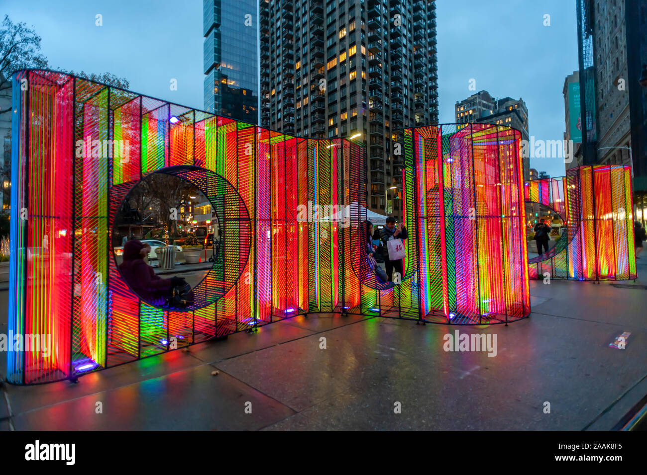 I visitatori di Flatiron Plaza di New York Lunedì, Novembre 18, 2019 interagiscono con ÒZiggyÓ creato da Hou de Sousa. L'installazione di Natale è il fulcro del Flatiron/23rd Street del Partenariato per la programmazione di vacanza, Ò23 Giorni di Flatiron CheerÓ. ÒZiggyÓ contiene 27.000 piedi di cavo iridescenti illuminati dalla luce UV. (© Richard B. Levine) Foto Stock