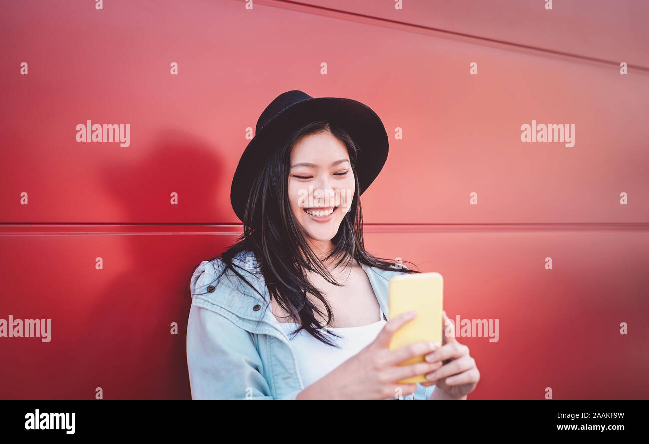 Felice ragazza cinese utilizzando il telefono cellulare per esterno - Asian social influencer donna per divertirti con le nuove tendenze di applicazioni dello smartphone Foto Stock