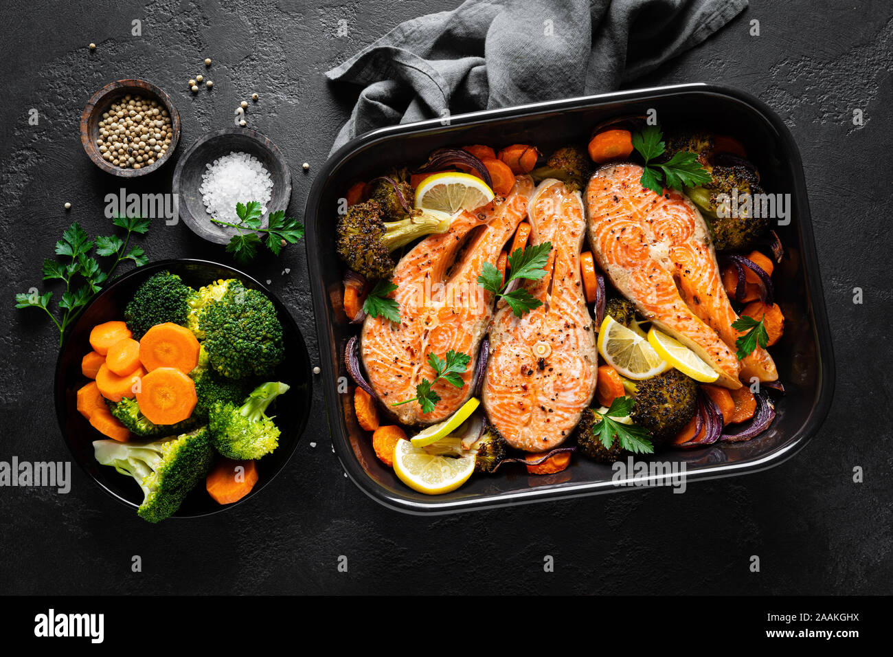 Salmone. Di salmone al forno tranci di pesce con verdure, broccoli, la  carota e la cipolla su sfondo nero, vista dall'alto Foto stock - Alamy