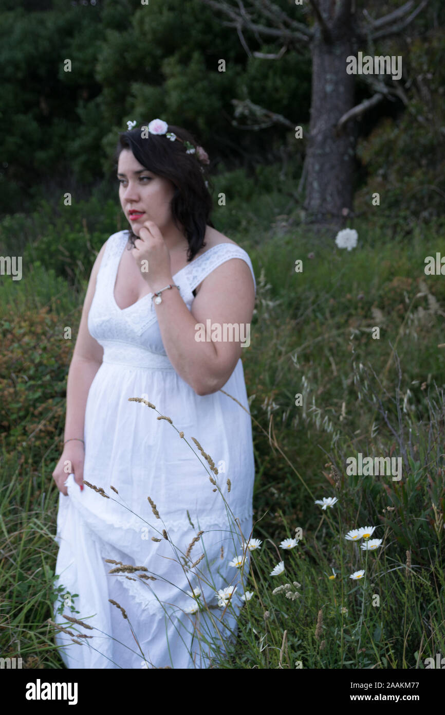 Moda boho Hippie donna in abito bianco e archetto di fiori nel campo Foto Stock