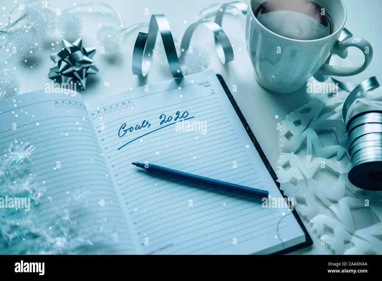 Gli obiettivi 2020 scritto su un diario con luce calda, caffè o tè e decorazione. Felice Anno Nuovo e motivazione consept sfondo Foto Stock