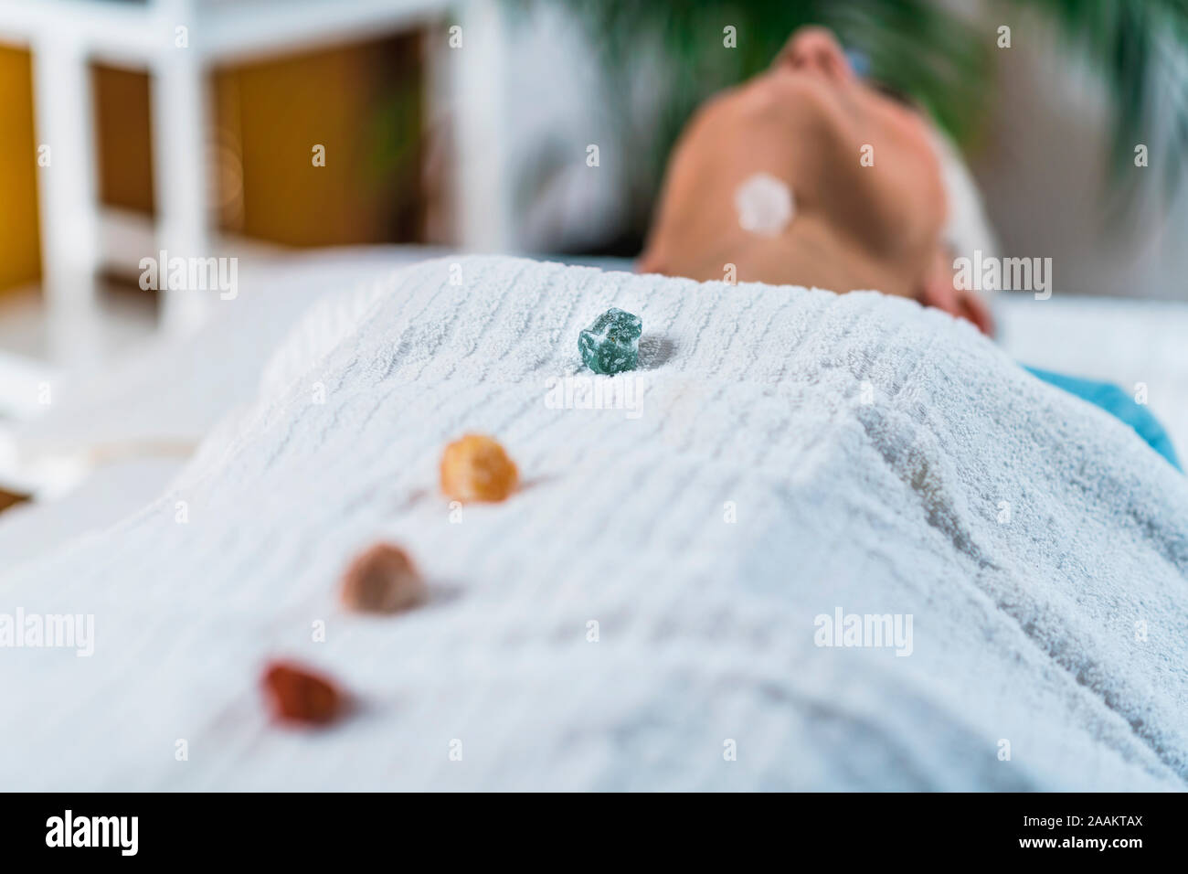 La guarigione e il bilanciamento dei chakra terapia. Donna anziana sdraiato sul lettino da massaggio e godendo del chakra del cuore di trattamento di guarigione. Foto Stock