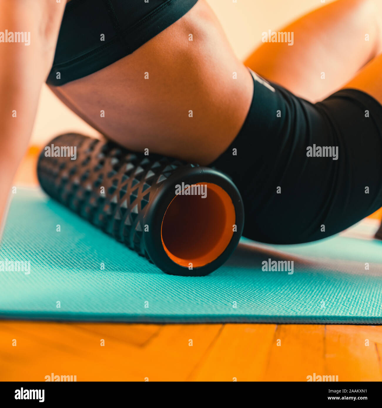 Atleta femminile Stretching schiena con il rullo in gomma spugna. Foto Stock