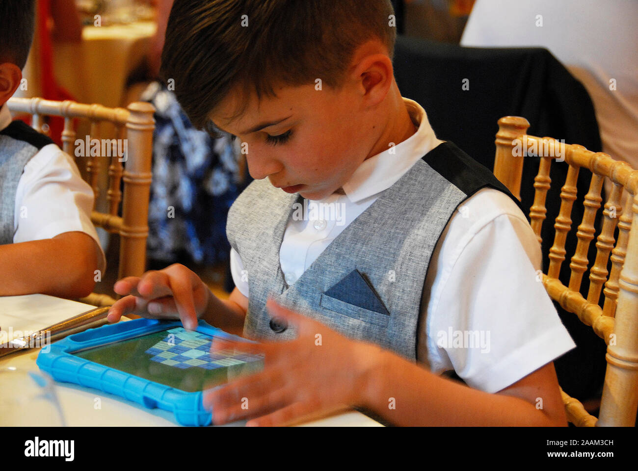 Un giovane bambino utilizzando un ipad. Foto Stock