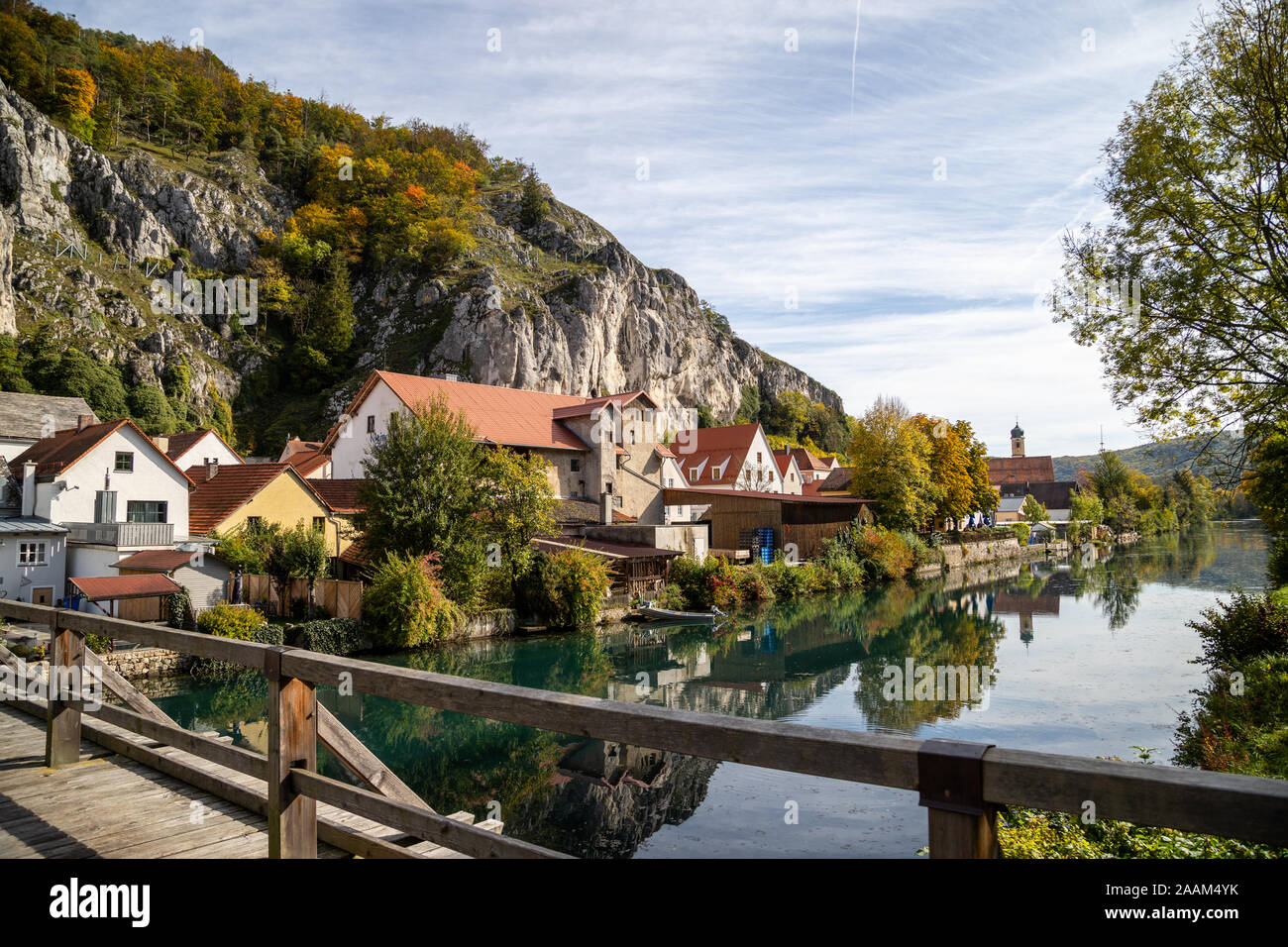 Idillica vista sul villaggio Markt Essing in Baviera, Germania con il fiume Altmuehl, altissime rocce in background e un ponte di legno in primo piano o Foto Stock