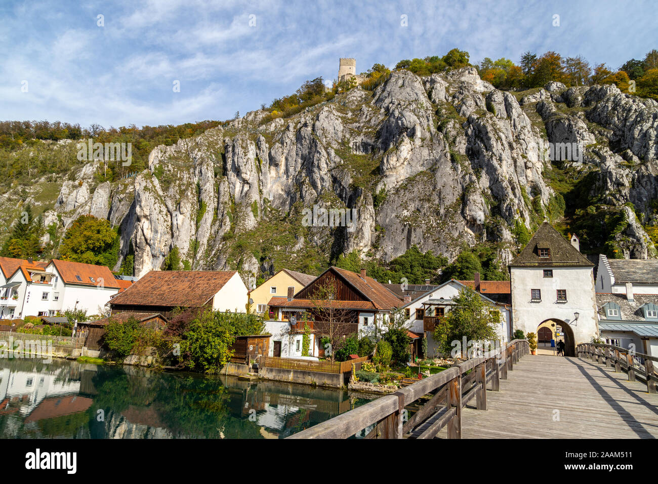 Idillica vista sul villaggio Markt Essing in Baviera, Germania con il fiume Altmuehl, altissime rocce in background e un ponte di legno in primo piano o Foto Stock