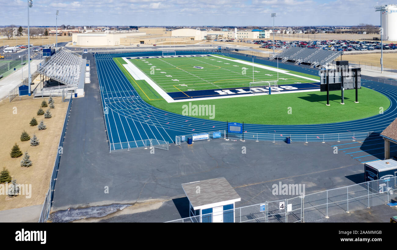 Un drone/Vista aerea di Plainfield High School del sud e football soccer stadium, circondato da un blu acceso via. Foto Stock