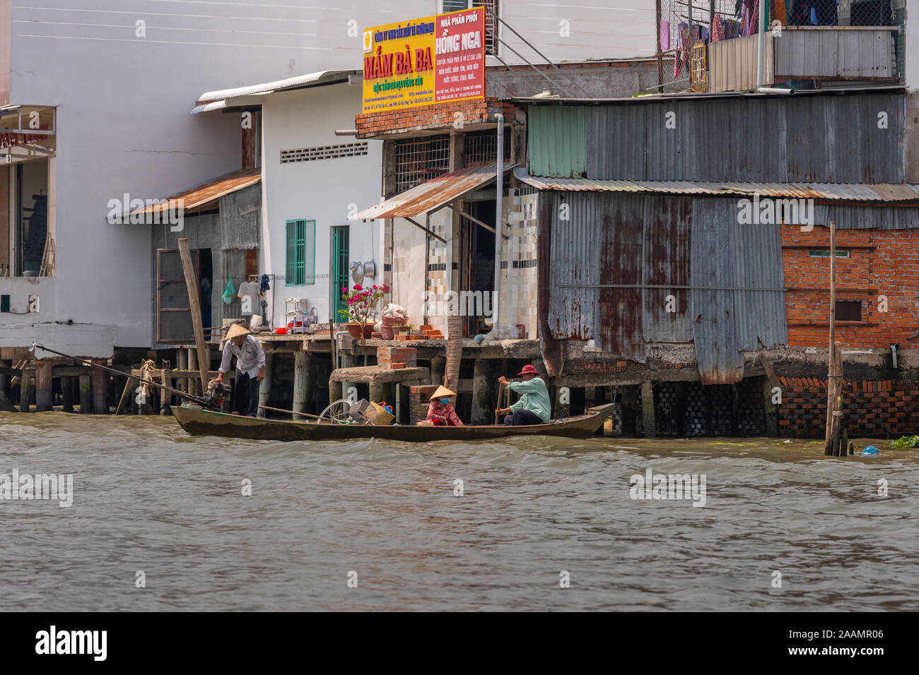 In Cai Be, il Delta del Mekong, Vietnam - Marzo 13, 2019: lungo quello dei Kinh 28 canal. Famiglia torna in piccoli cano da flottante sul mercato all'ingrosso passando da business b Foto Stock