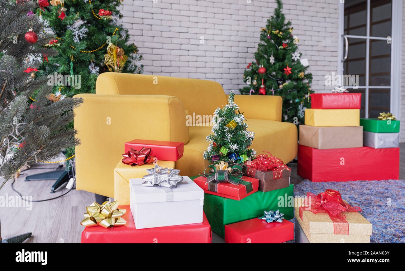 Natale soggiorno, divano giallo con alberi di Natale, confezioni regalo e le decorazioni di Natale Foto Stock