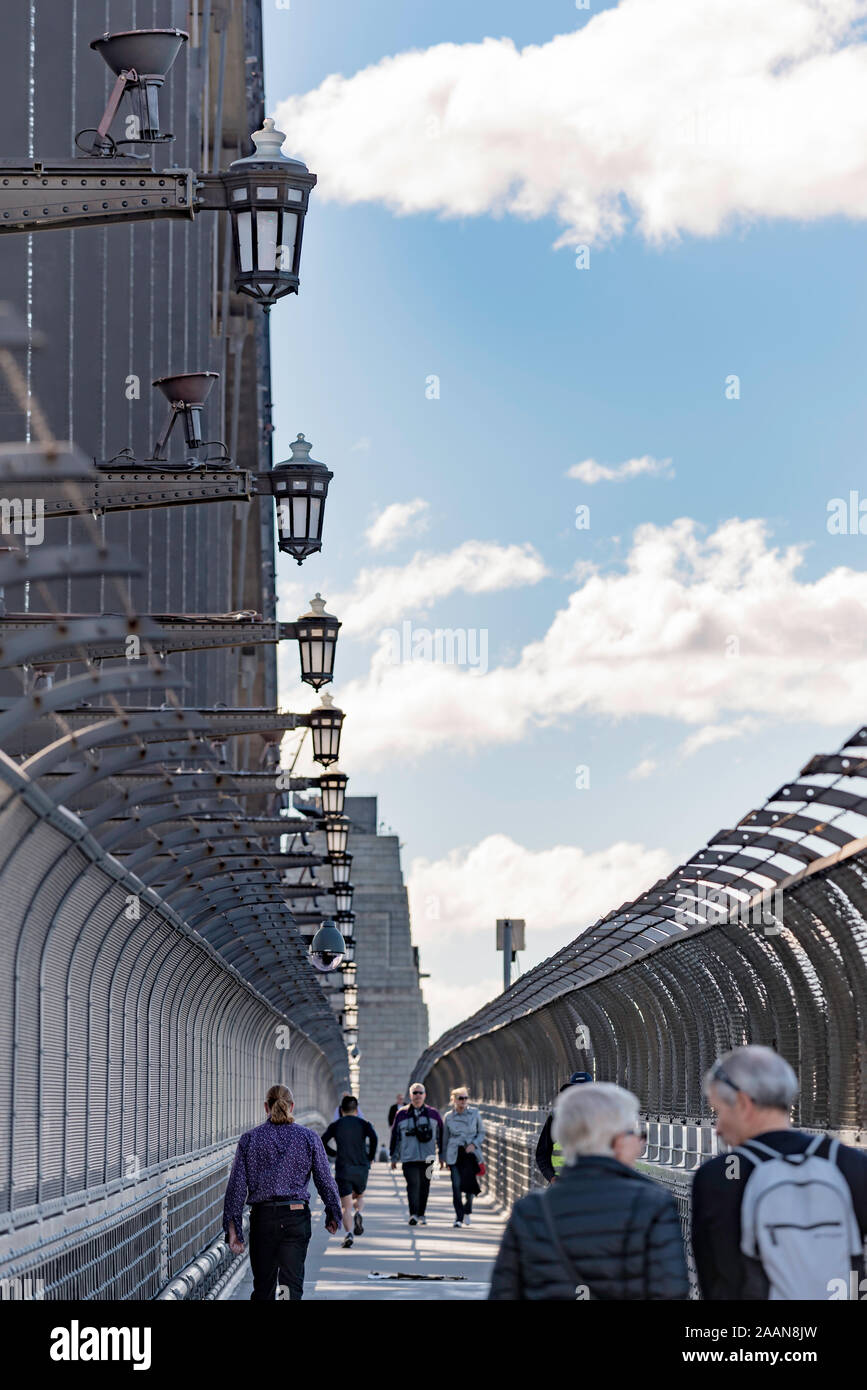 Un'immagine verticale delle persone che camminano sopra il Ponte del Porto di Sydney sotto il recentemente restaurato e installato lanterna originale luci. Foto Stock