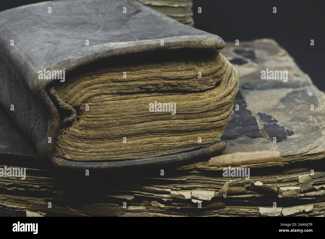 Composizione astratta vista laterale del vecchio, invecchiato, polveroso e strappata libri posta su ogni altro nella parte anteriore del fondo nero Foto Stock