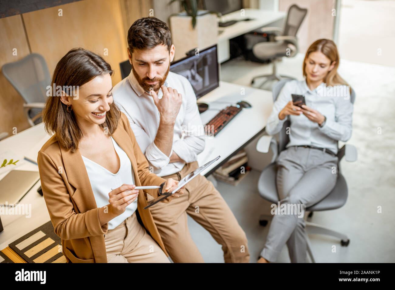 I colleghi aventi qualche lavoro creativo utilizzando tavoletta digitale e matita in ufficio moderno studio. Concetto di progettazione digitale su un tablet Foto Stock