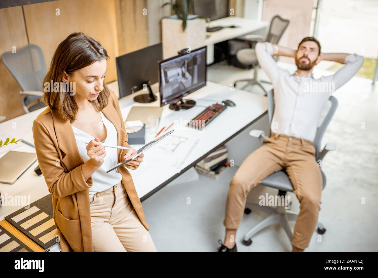 I colleghi aventi qualche lavoro creativo utilizzando tavoletta digitale e matita in ufficio moderno studio. Concetto di progettazione digitale su un tablet Foto Stock