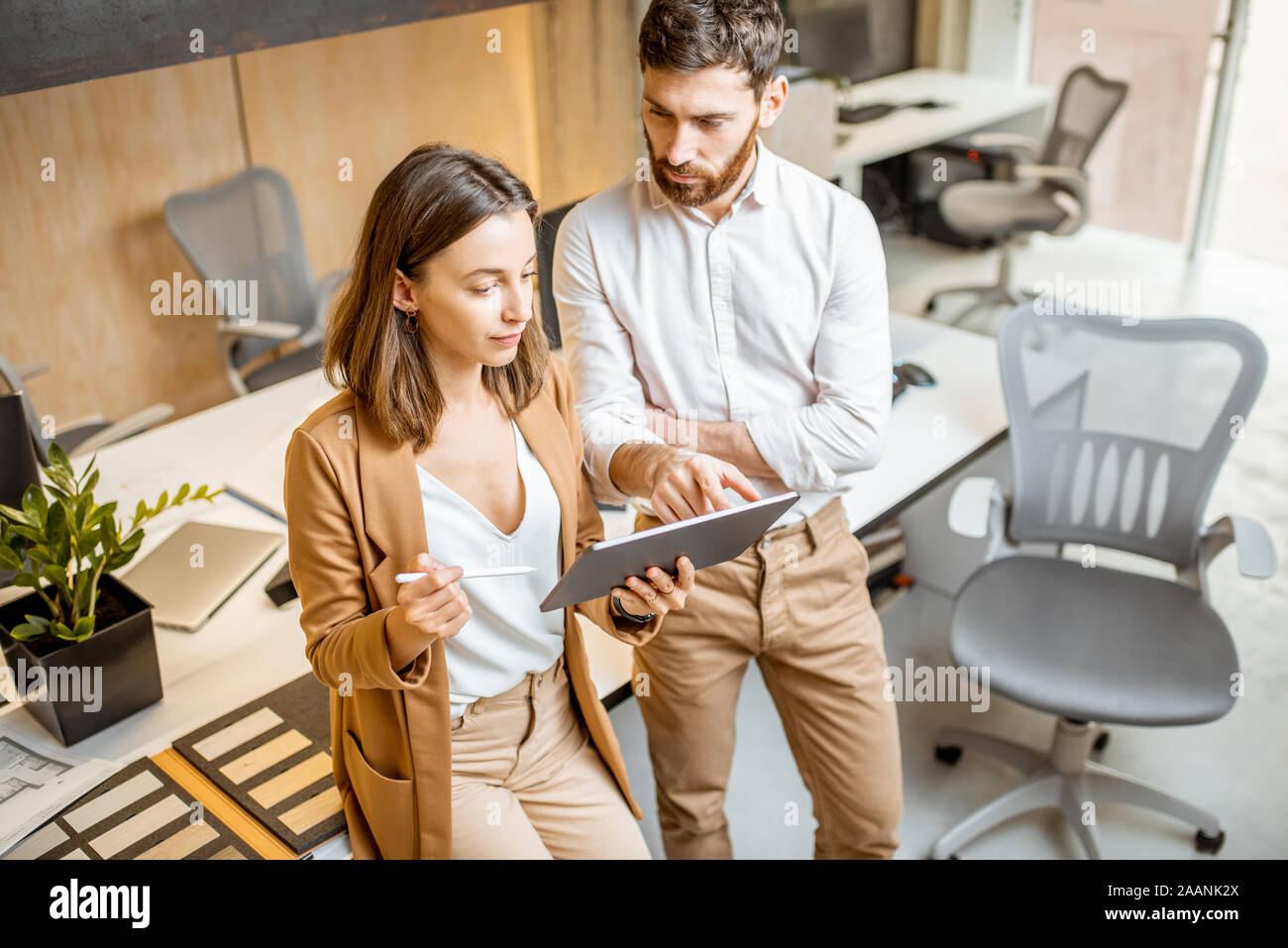 I colleghi aventi qualche lavoro creativo utilizzando tavoletta digitale e matita in ufficio moderno studio. Concetto di progettazione digitale su un tablet Foto Stock