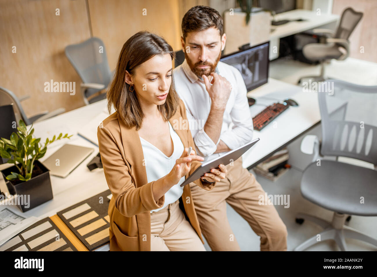 I colleghi aventi qualche lavoro creativo utilizzando tavoletta digitale e matita in ufficio moderno studio. Concetto di progettazione digitale su un tablet Foto Stock