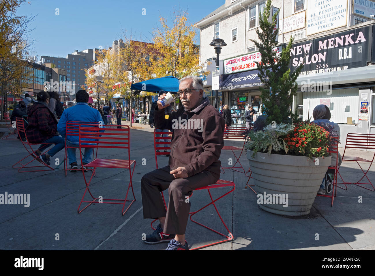 Un uomo (presumibilmente un immigrato) bere il tè nella diversità Plaza in Jackson Heights in una fredda giornata di caduta. Nel Queens, a New York City. Foto Stock