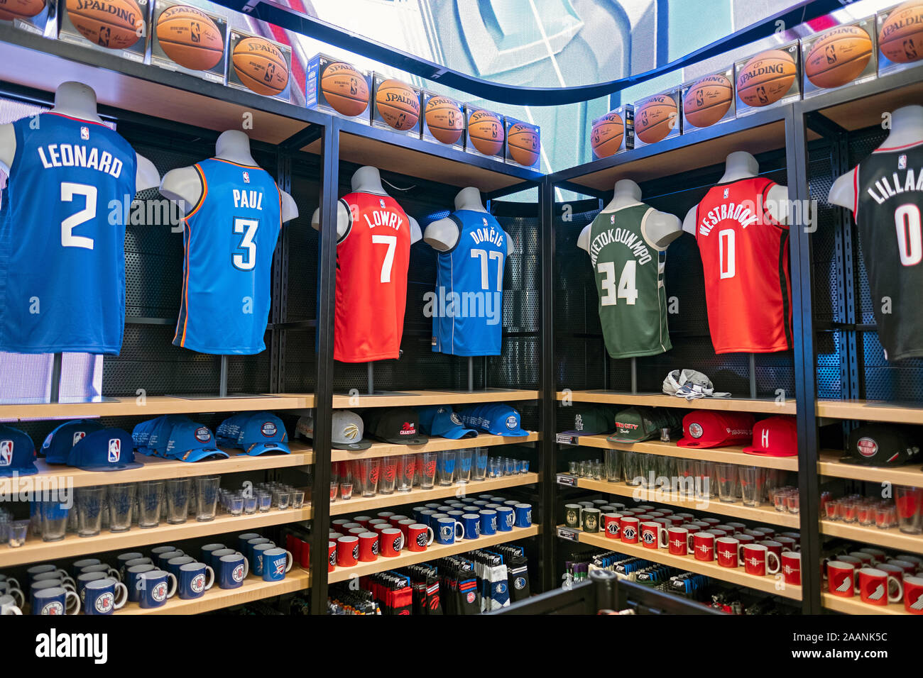 Maglie, tappi, tazze, cappelli e di altra merce in vendita presso il negozio NBA sulla Quinta Avenue nel centro di Manhattan. Foto Stock