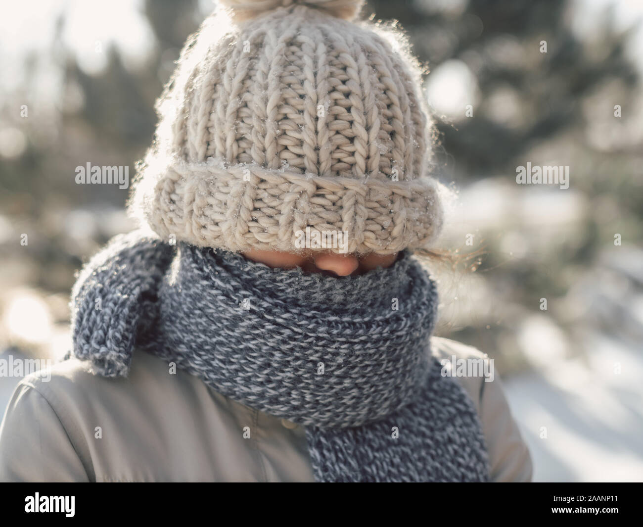 Ritratto di donna divertente nel casual abbigliamento invernale hat sciarpa  e cappotto. Giovane donna sofferente in un freddo inverno all'esterno.  Carino divertente gara di misto Caucasian donna asiatica di close-up in  piedi