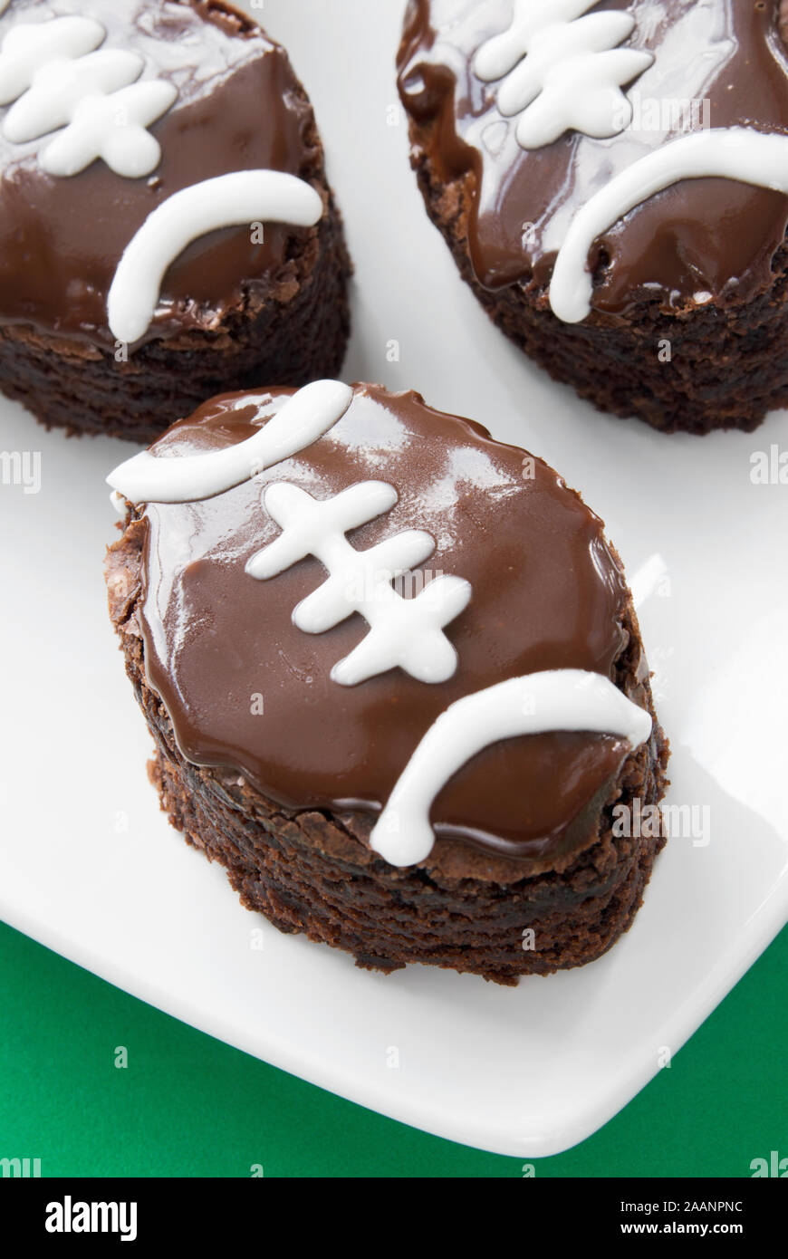 In casa a forma di pallone da football double fudge cioccolato brownie ghiacciata con tubazioni di bianco. Definizione poco profonda del campo. Foto Stock