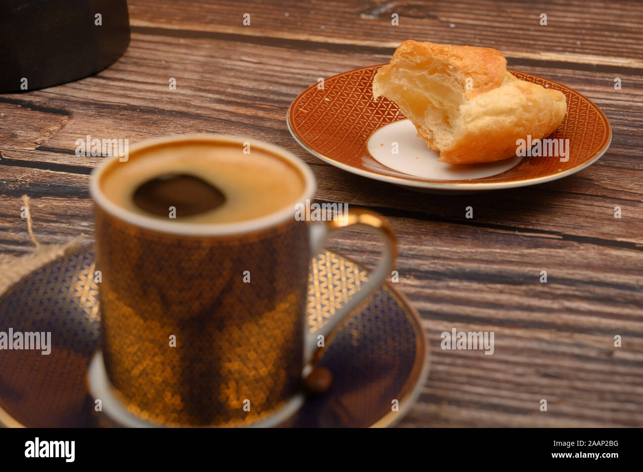 Tazza di caffè e croissant su sfondo di legno. Close up Foto Stock