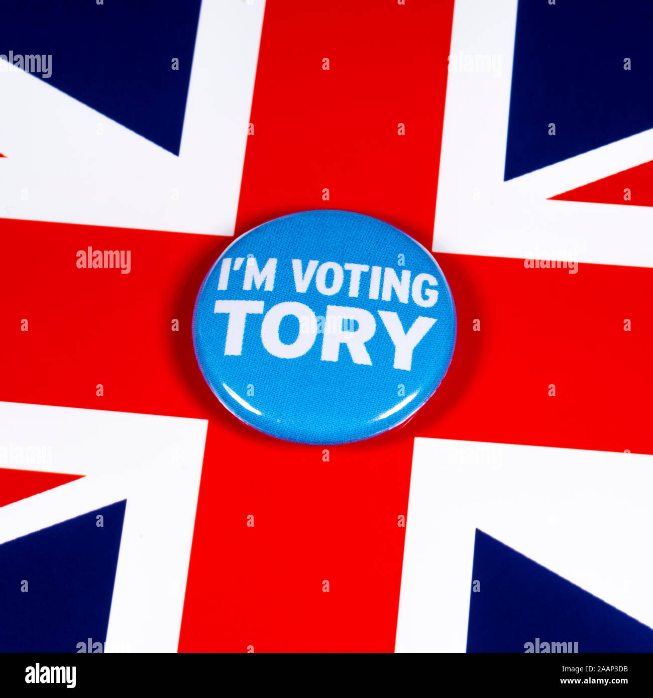 London, Regno Unito - 21 Novembre 2019: sto votando Tory pin badge, nella foto sopra il Regno Unito bandiera. Le elezioni generali britanniche si svolge il 12 Dic Foto Stock