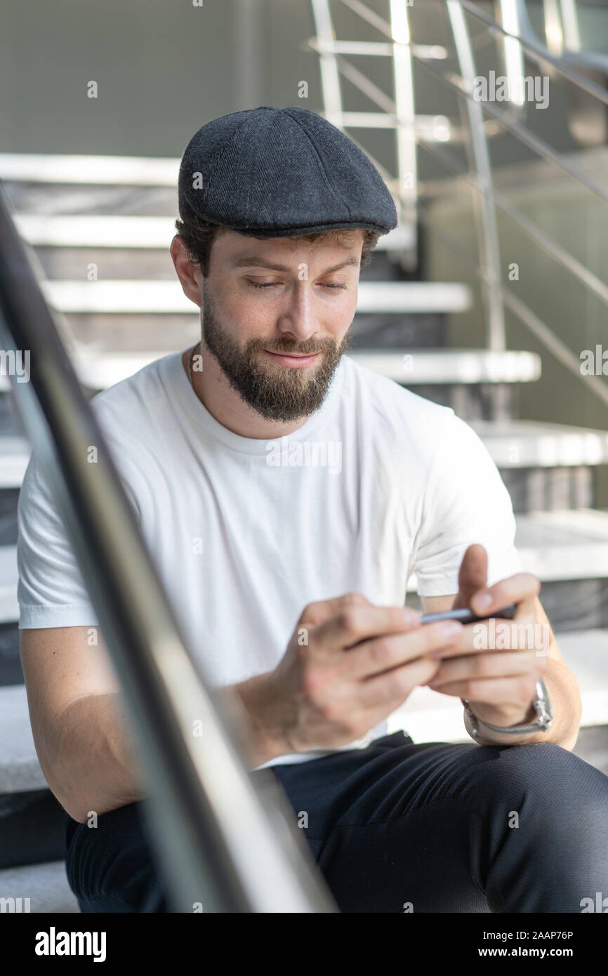 Giovane uomo giocare giochi mobile sul telefono. Utilizza lo smartphone per i videogame. Foto Stock