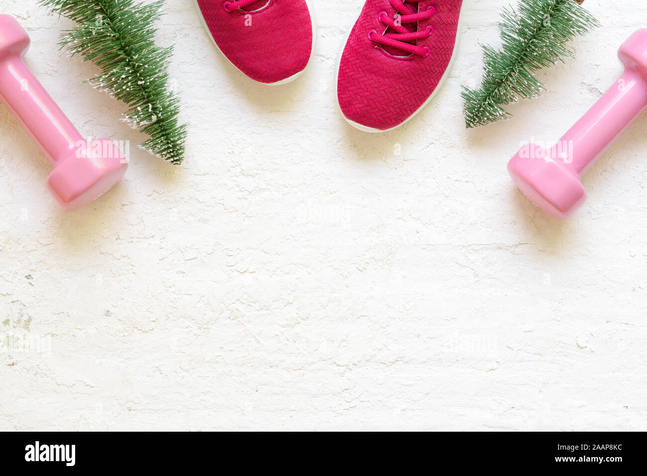 Natale acive sano stile di vita piatta composizione laici con le scarpe da ginnastica, manubri, albero di natale di grunge bianco sullo sfondo di legno. Buon Natale e Foto Stock