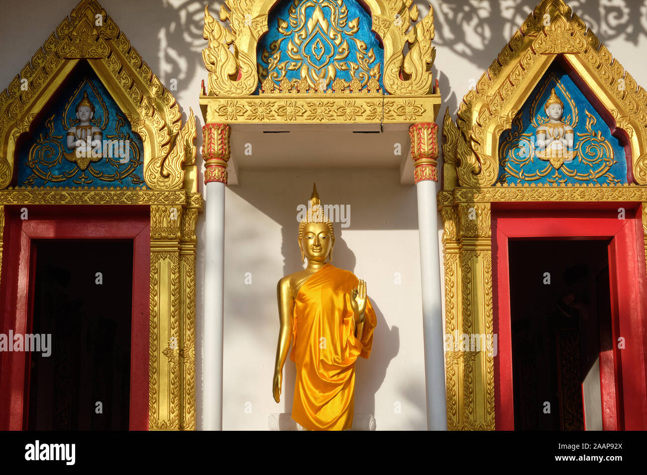 La figura di un Buddha in piedi che mostra la mudra della mano (gesto della mano) di Abhaya, impaurezza; Wat Monkon Nimit, Phuket Town, Thailandia Foto Stock