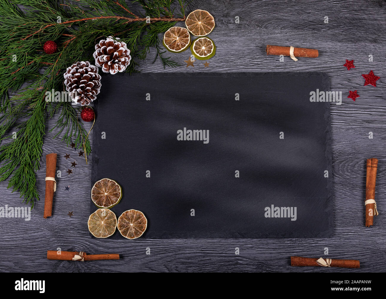 Una oscura un vassoio di formaggi con copia spazio per il testo. Lay piatto. Alimenti naturali come ingrediente per la cottura o decorazioni di Natale per la casa. Foto Stock