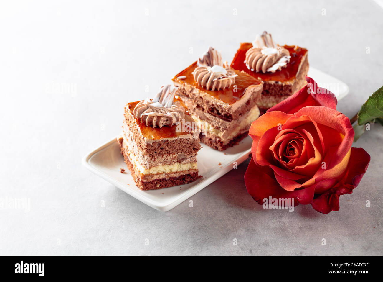 Torte a strati con rose su un bianco marmorean tabella. Colazione romantica. Foto Stock