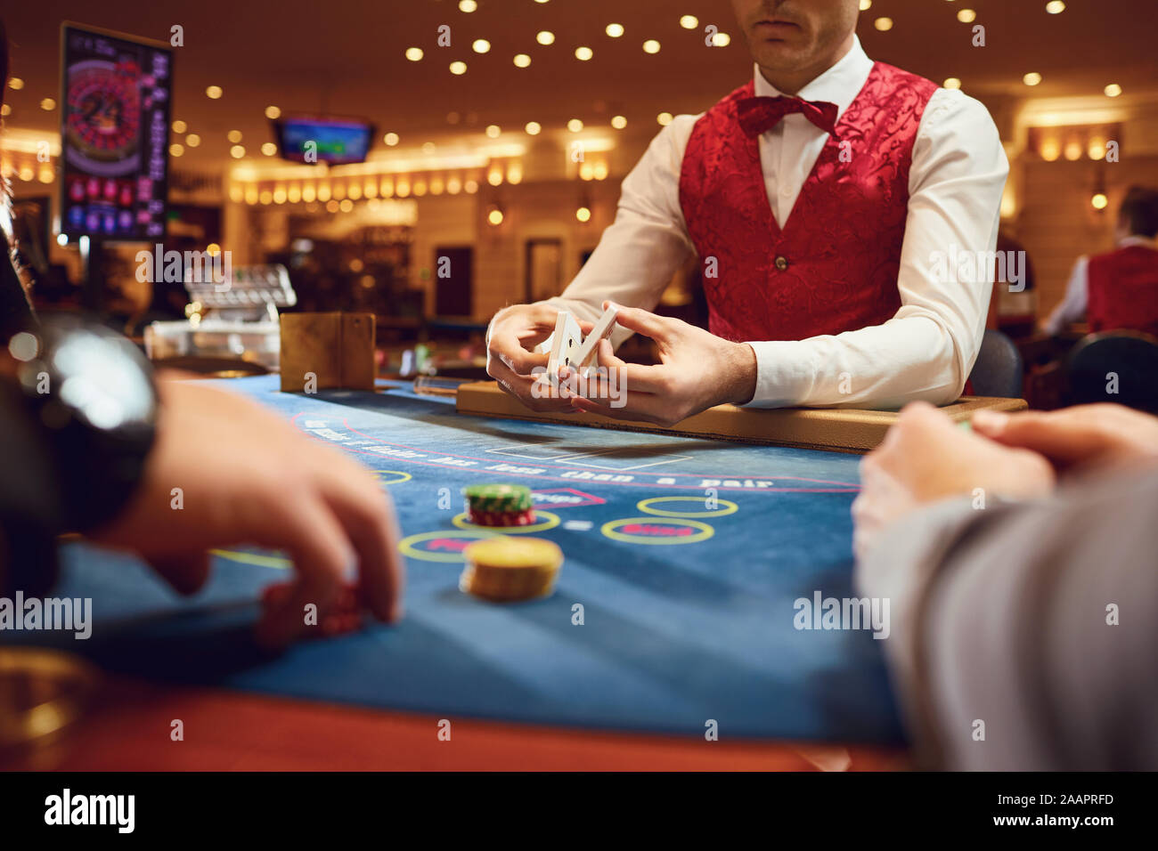 Croupier contiene carte da poker nelle sue mani a una tabella in un casinò. Foto Stock