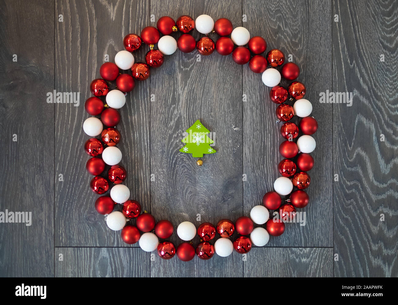 Rosso e Bianco Natale baubles collocato in un cerchio molto simile a una corona, con un verde a forma di albero ornamento nel centro Foto Stock Rosso e Bianco Natale baubles collocato in un cerchio molto simile a una corona, con un verde a forma di albero ornamento nel centro Foto Stock