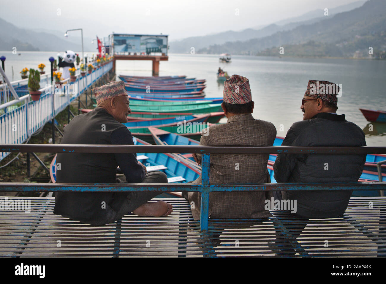 Locale uomini nepalese in chat in riva al lago Foto Stock