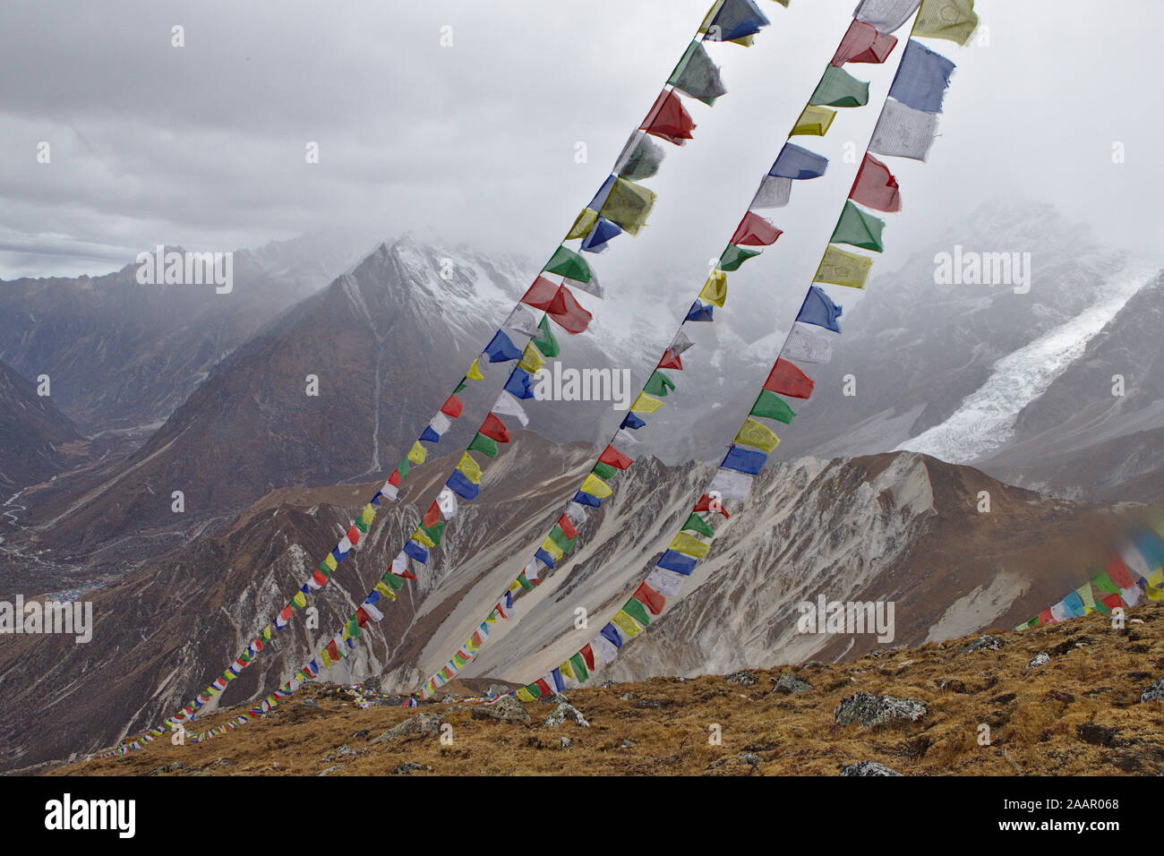 Bandiere di preghiera di fronte montagne innevate della Valle di Langtang (salita a Kyanjin Ri) Foto Stock