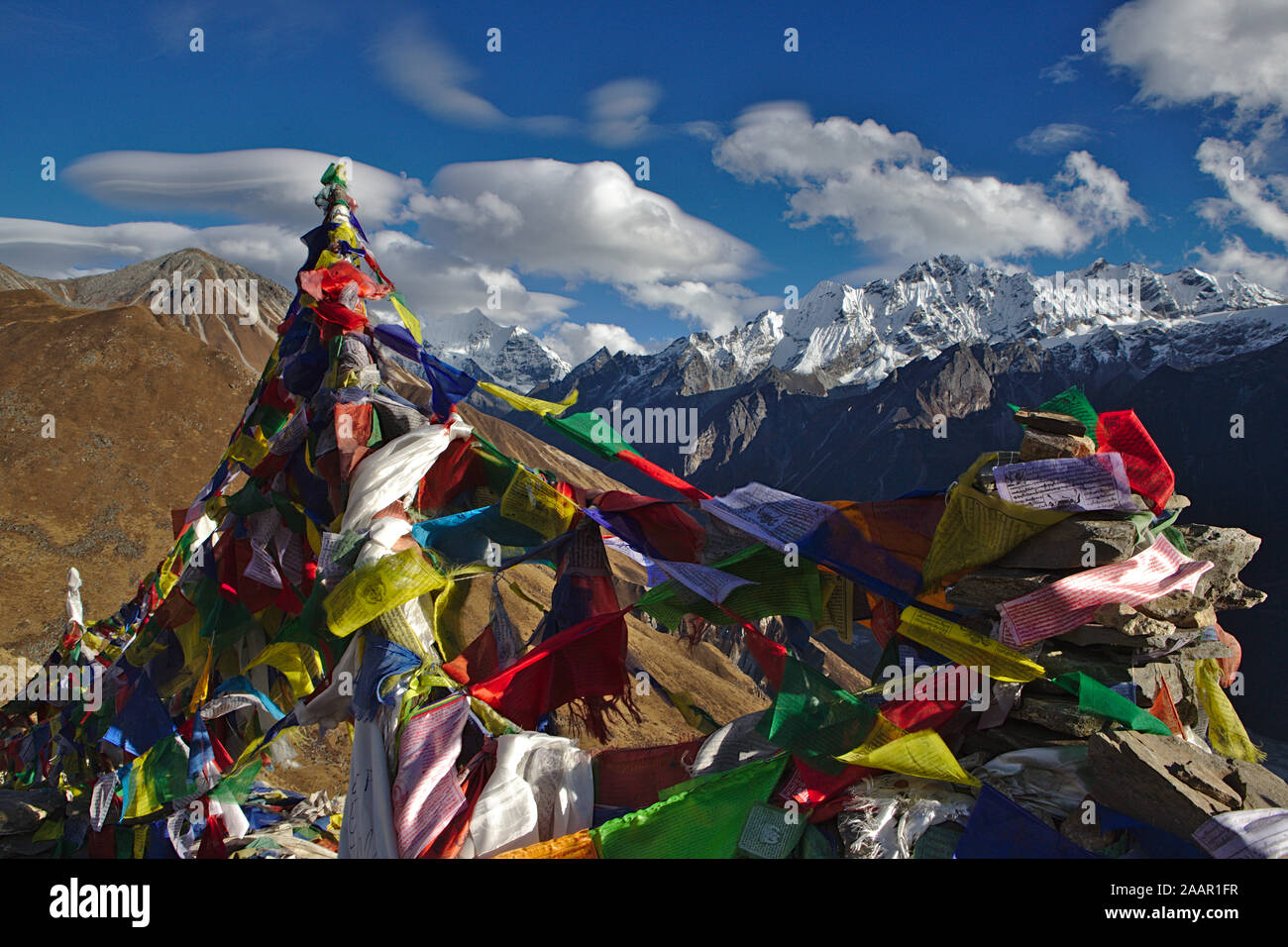 Bandiere di preghiera di fronte montagne innevate della Valle di Langtang (salita a Kyanjin Ri) Foto Stock